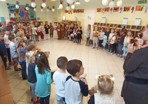 Dzieci stoją w kręgu i spiewają piosenke o pluszowym misiu.