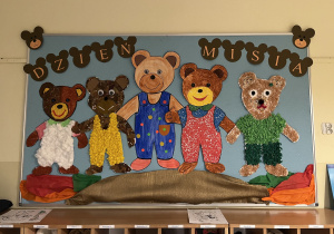 Dekoracja w szatni przedszkola wykonana przez poszczególne grupy przedstawiająca pięć misiów w kolorach grup.