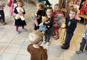 Dzieci bawią się i tańczą podczas balu wraz ze swoimi maskotkami.