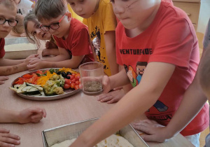 Dzieci ozdabiają focaccie ulubionymi warzywnymi składnikami