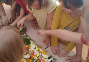 Dzieci ozdabiają focaccie ulubionymi warzywnymi składnikami