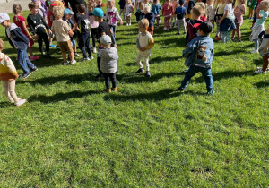 Dzieci biorą udział w zabawach na świeżym powietrzu.