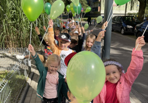 Dzieci idą z balonami na spacer w okolicy przedszkola.
