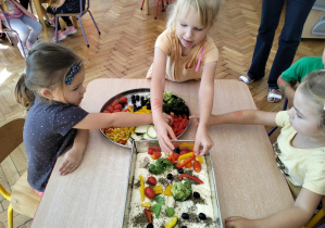 Dziewczynki układają warzywa