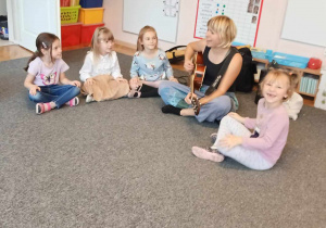 Dzieci bawią się przy dźwiękach gitary