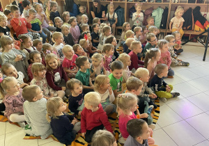 Dzieci na widowni oglądają przedstawienie lalkowe.