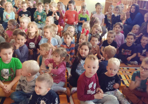 Dzieci na widowni oglądają przedstawienie lalkowe.