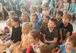 Dzieci oglądają występ artystów.