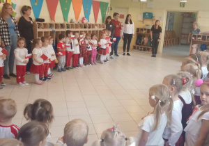 Dzieci zgromadzone w holu przedszkola śpiewają Hymn Polski