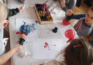 Dzieci malują bombki.
