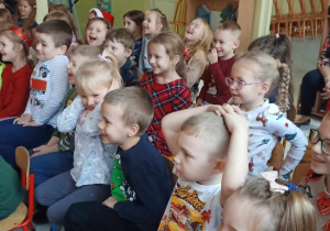 Dzieci zgromadzone w dolnym holu oglądają przedstawienie lalkowe