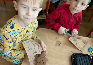 Dzieci wycinają i projektują swoje dinozaury.