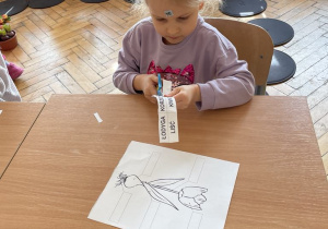 Dziecko uzupełnia kartę pracy o tulipanie.