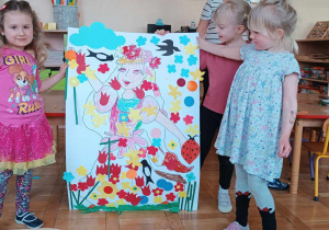 Dzieci prezentują skończony plakat wiosny.