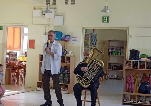 Muzycy prezentują instrumenty przed dziećmi