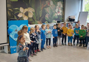 Dzieci śpiewają piosenkę dla zgromadzonych uczestników spotkania